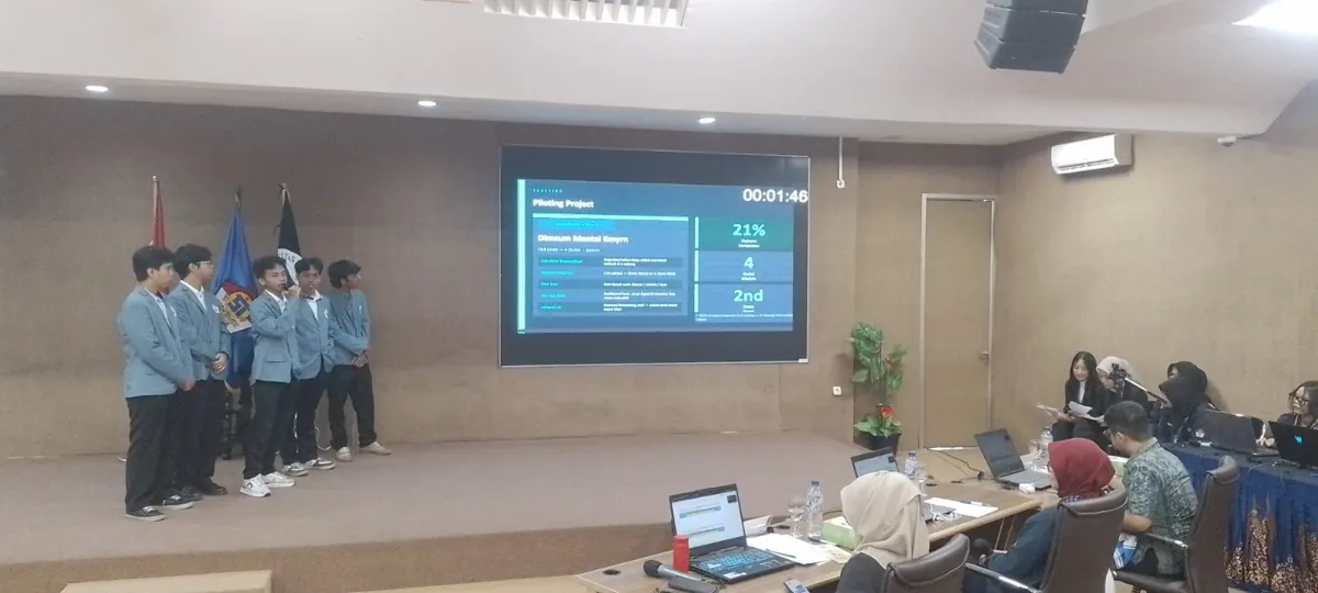 Tim berjas almamater biru presentasi di depan juri dengan penghitung waktu di layar